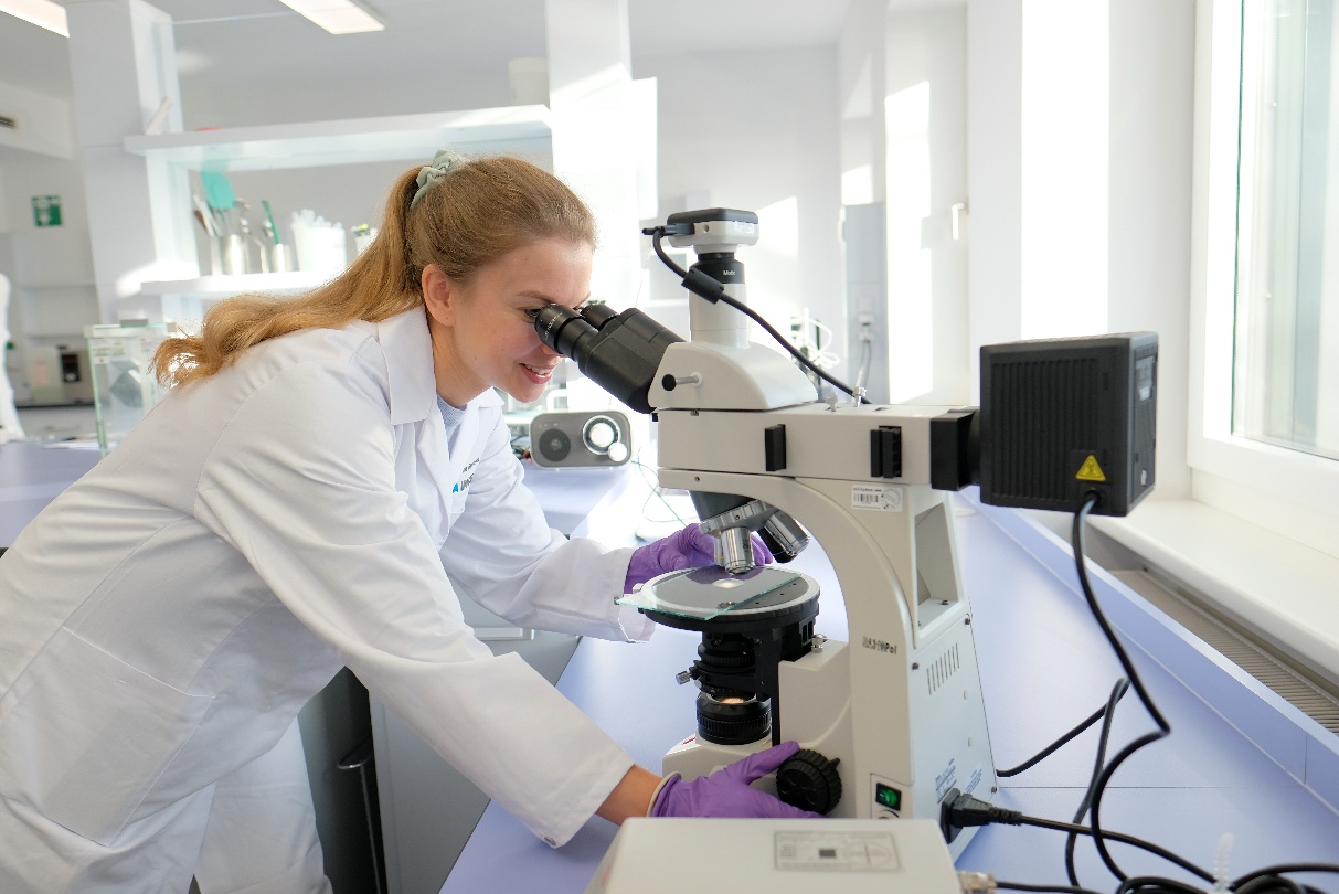 A person looking through a microscopeAI-generated content may be incorrect.