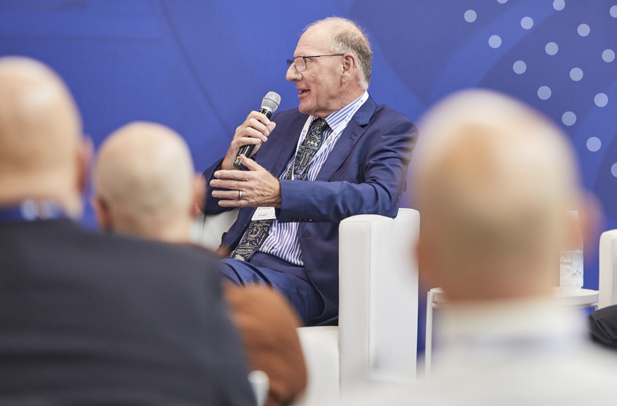 A person in a suit holding a microphoneAI-generated content may be incorrect.