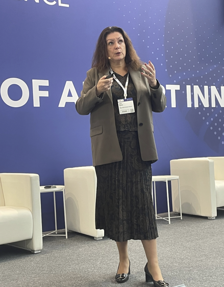 A person standing in front of a blue wallAI-generated content may be incorrect.