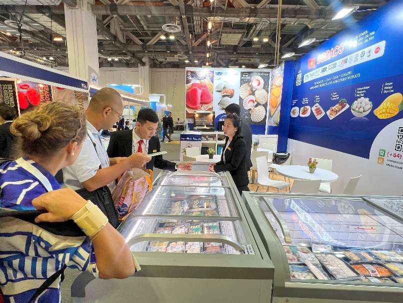 People standing in a room with a display caseDescription automatically generated