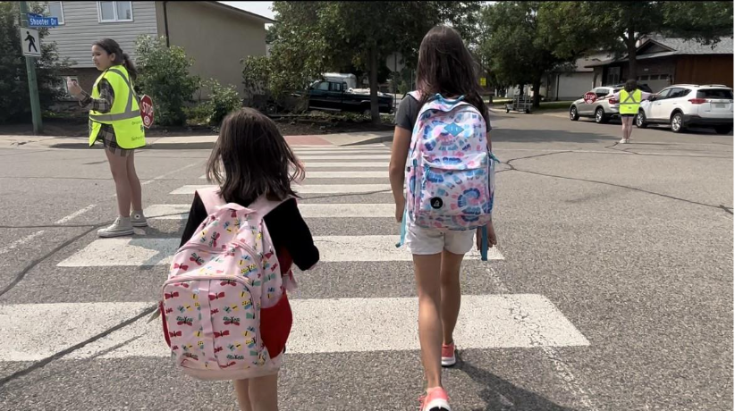 Two girls walking across a crosswalkAI-generated content may be incorrect.