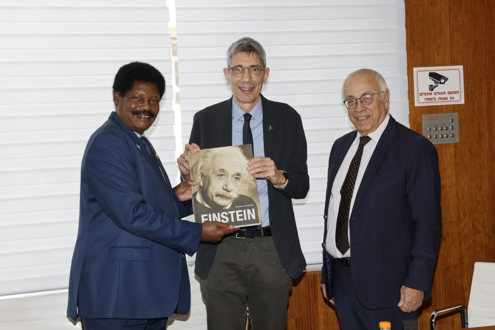 A group of men holding a bookAI-generated content may be incorrect.