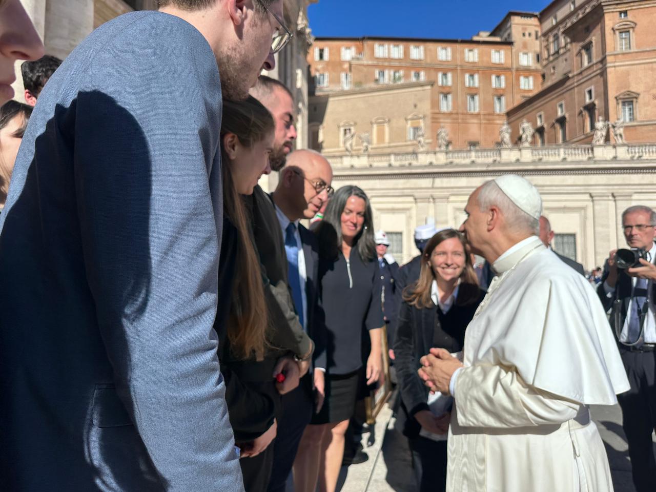 A group of people standing around a person in a white robeAI-generated content may be incorrect.