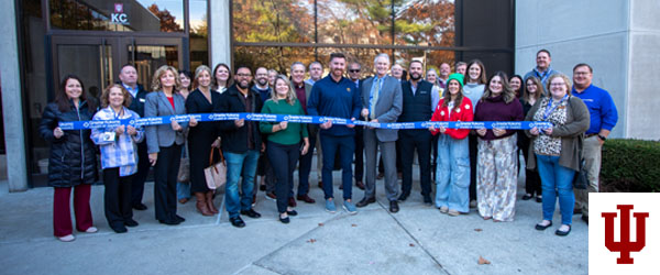 a group of people in front of a blue ribbon