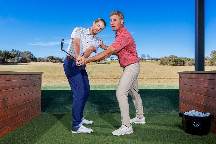 A person hitting a golf ball with another personAI-generated content may be incorrect.