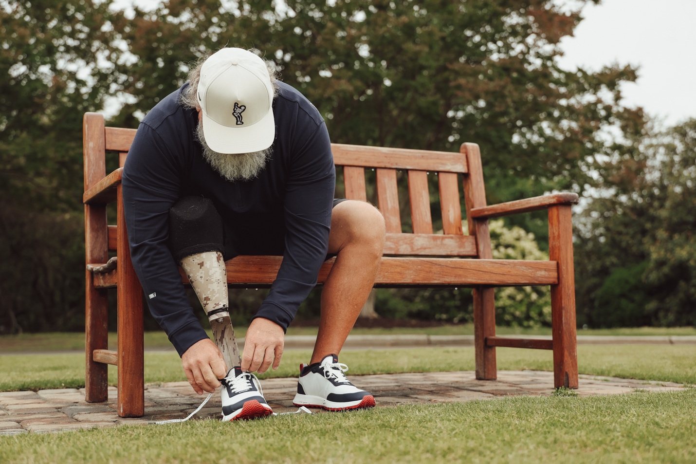 A person with prosthetic leg tying his shoelacesAI-generated content may be incorrect.