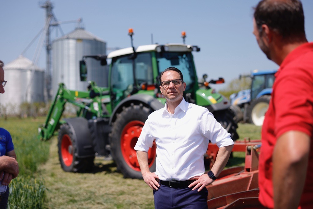 A person standing in front of a tractor

Description automatically generated with medium confidence